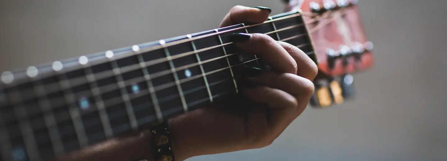 Hand shaping a chord on a guitar neck