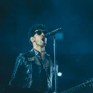 Singer at the microphone under blue stage light